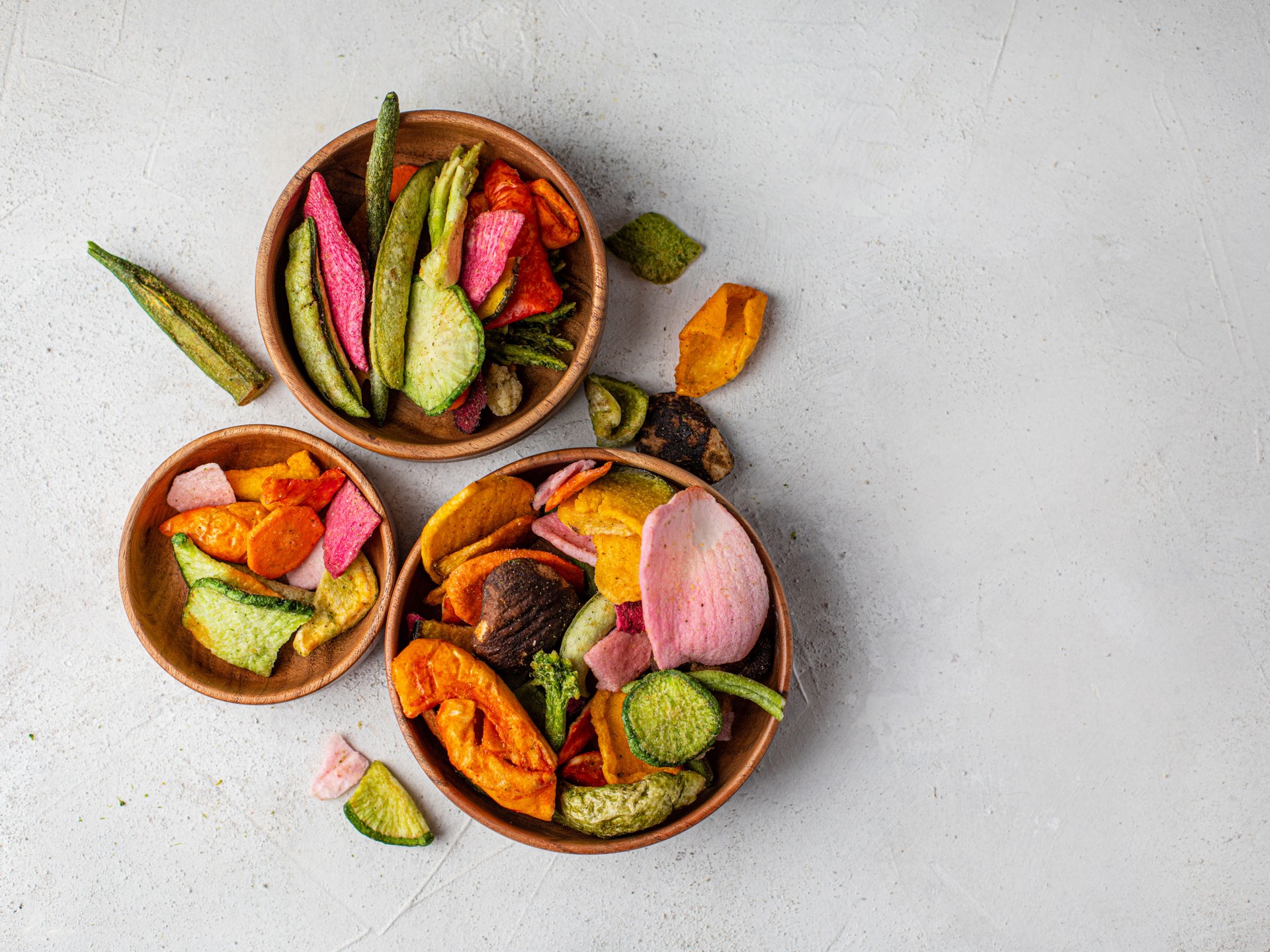 Dehydrated vegan chips in a wooden mango bowl.