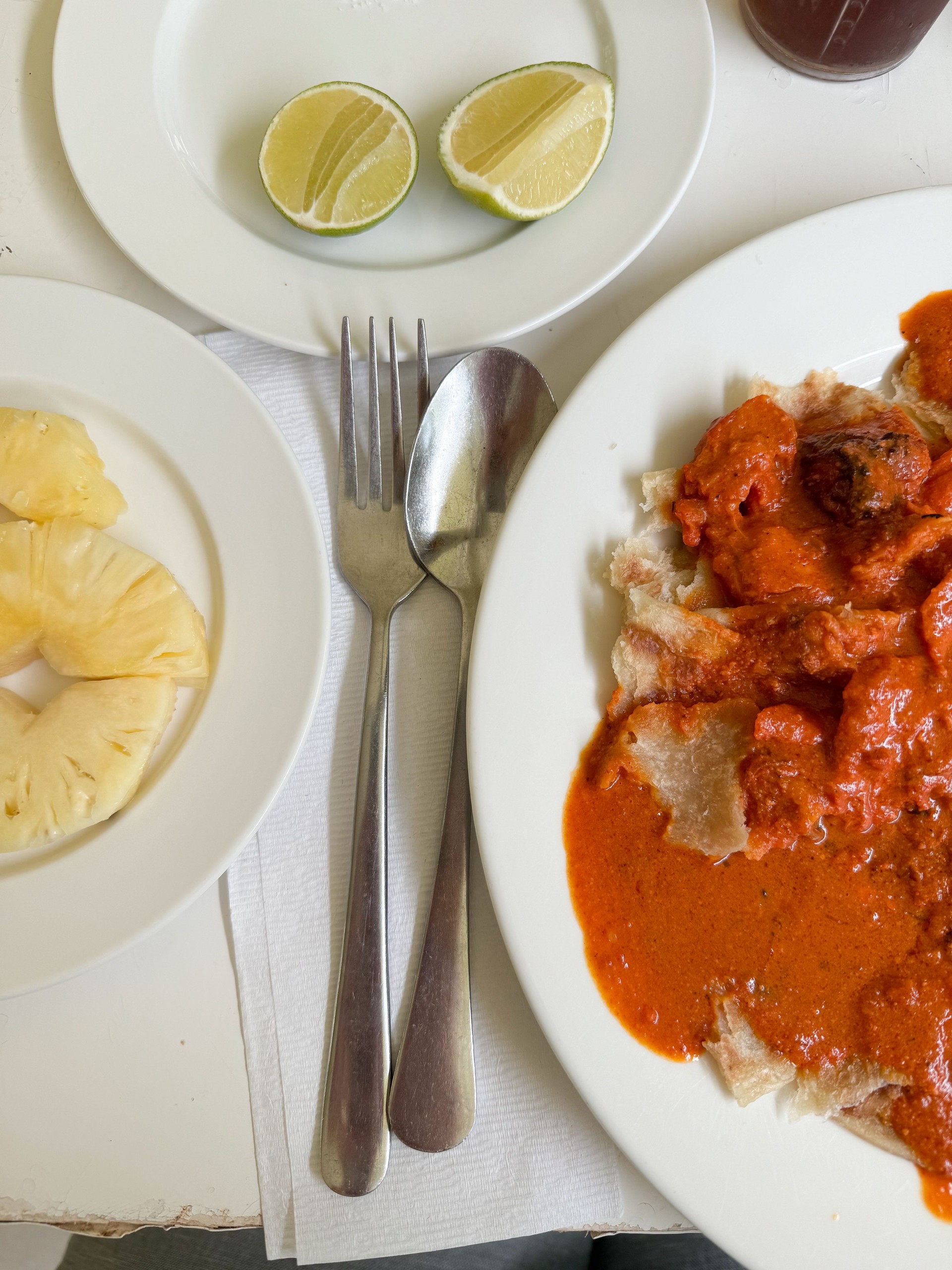 Eating Butter Chicken dish with paratha bread in simple Indian Restaurant